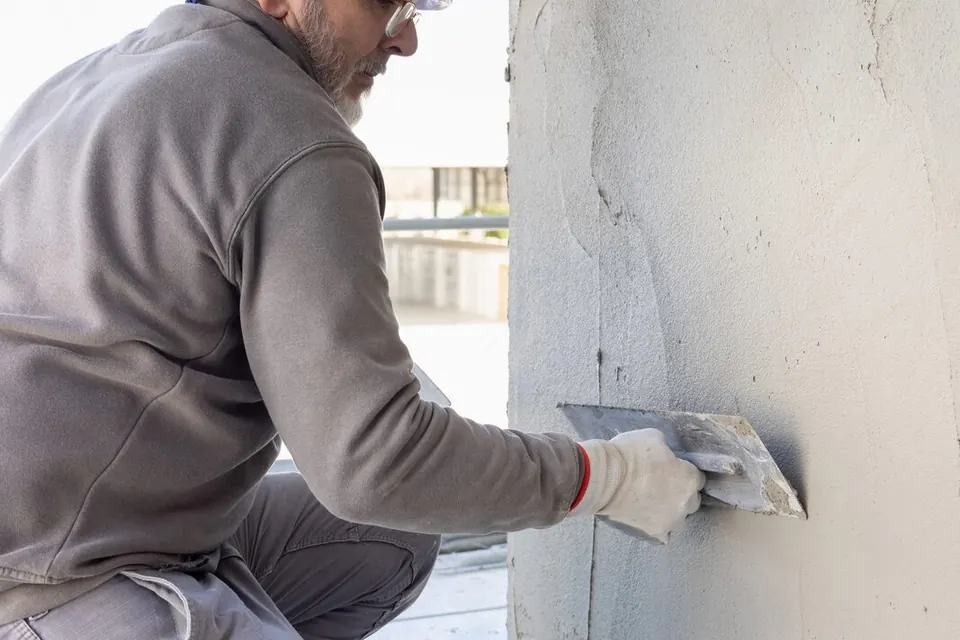 Artisan appliquant un enduit sur une façade